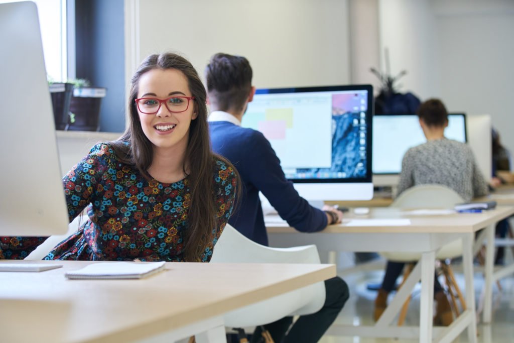 Career Focus - Software developer working on her computer at a modern office.