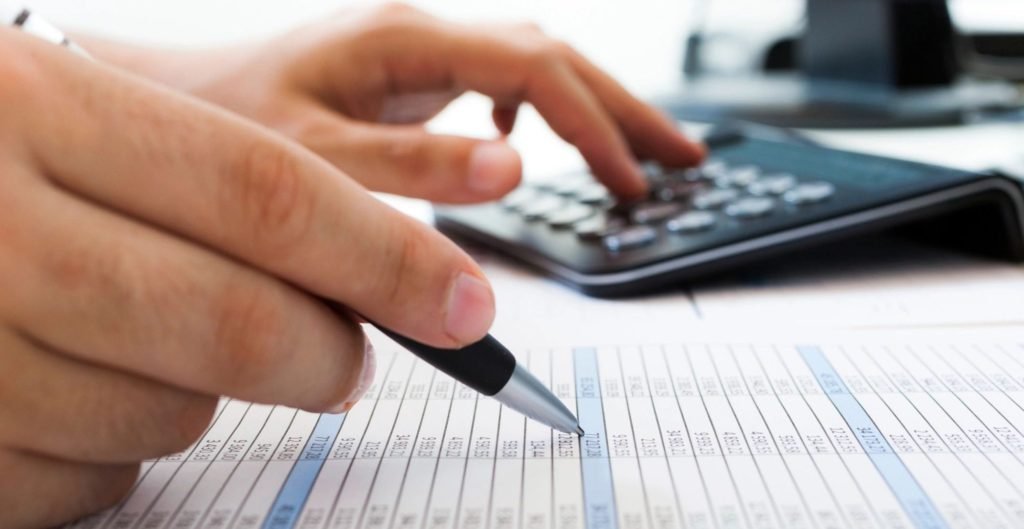 Financial Education - A person crunching numbers using a calculator.