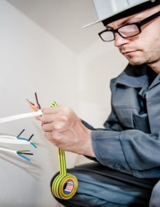 Made in the Trades - A male electrician cutting electrical tape.