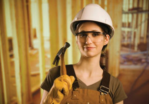 Made in the Trades - Woman with hardhat holding a hammer.